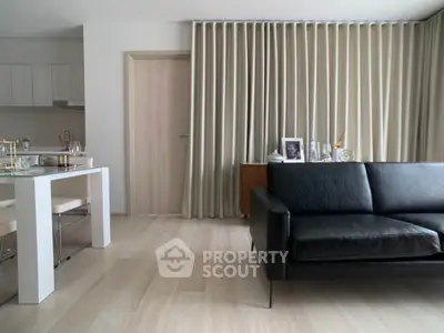 Modern living room with sleek black sofa and elegant dining area