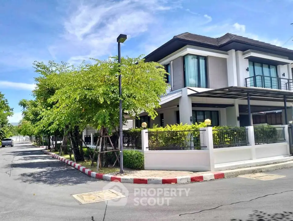 Charming corner unit house with lush greenery and modern architecture in a serene neighborhood.