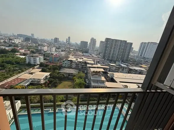 Stunning cityscape view from a high-rise balcony overlooking a sparkling pool.