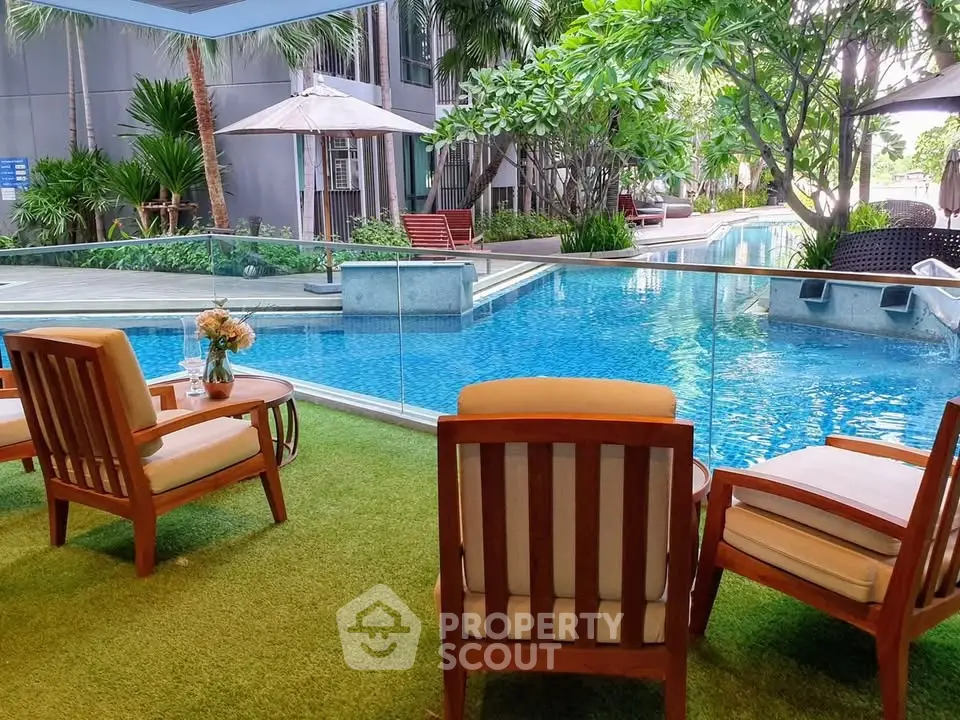 Luxurious poolside seating area with lush greenery and modern design.