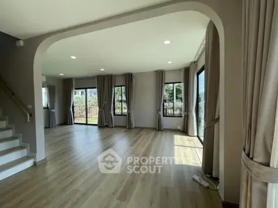 Spacious living room with large windows and wooden flooring