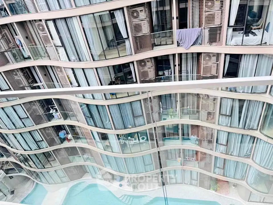 Modern apartment building with unique wave design and pool view