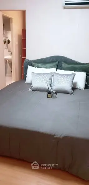 Cozy bedroom with plush bedding and modern decor, adjacent to a stylish bathroom.