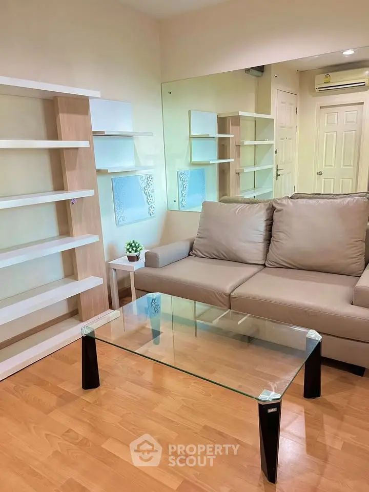 Modern living room with sleek glass coffee table and stylish shelving units.
