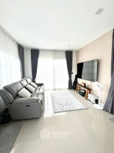 Spacious modern living room with large windows and sleek furnishings