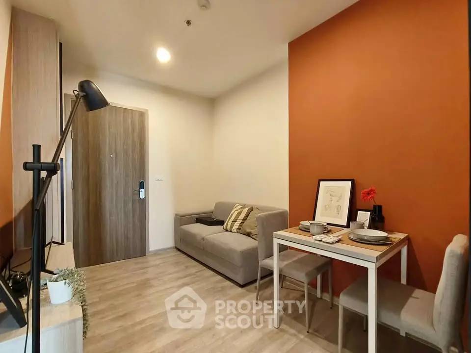 Modern living room with cozy sofa and dining area, featuring stylish decor and warm lighting.