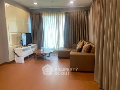 Spacious living room with cozy seating and natural light, perfect for relaxation and entertainment.