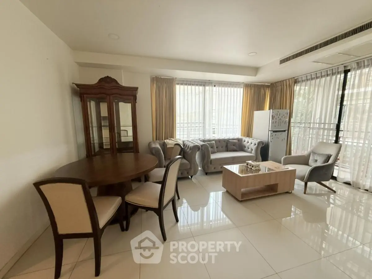 Spacious living room with elegant furniture and large windows offering natural light.