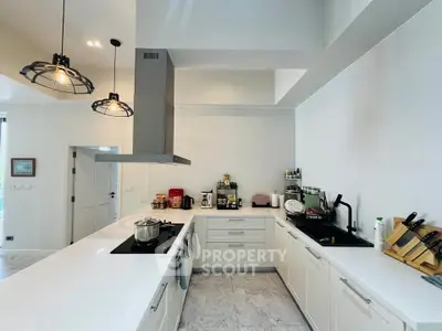 Modern kitchen with sleek white cabinetry and high-end appliances in a spacious open layout.