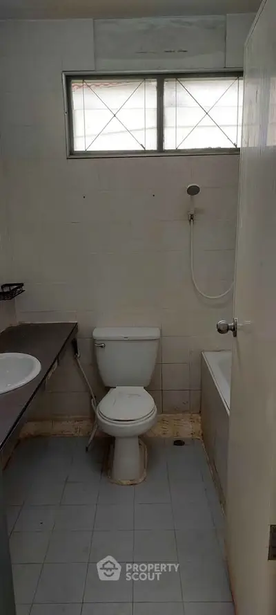 Compact bathroom with shower and toilet in a minimalist design.