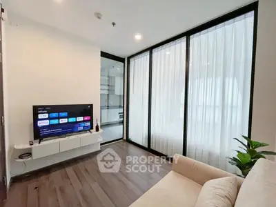 Modern living room with sleek design and large windows, featuring a cozy sofa and wall-mounted TV.