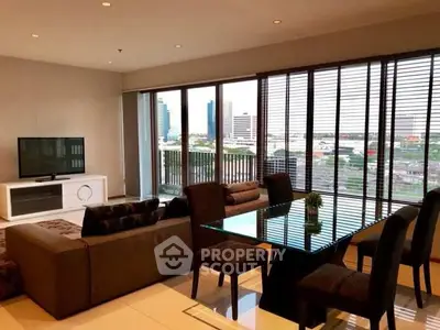 Modern living room with city view, stylish furniture, and large windows.