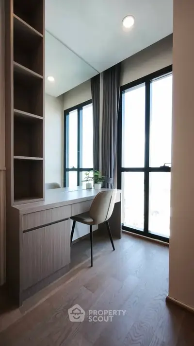 Modern study area with large windows and sleek furniture in a bright apartment.