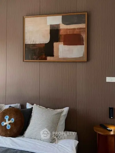 Stylish bedroom with modern art and cozy pillows, perfect for relaxation.