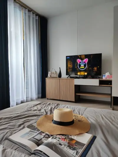 Modern bedroom with stylish decor, featuring a TV and elegant curtains, perfect for relaxation.