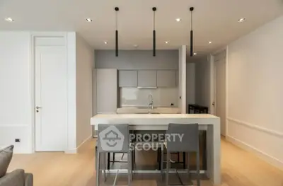Modern kitchen with sleek island and stylish bar stools in open layout apartment.