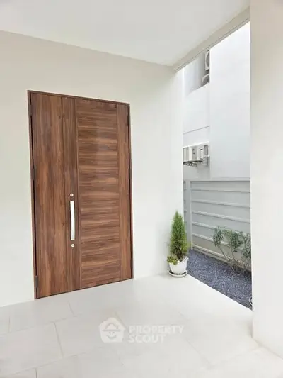 Elegant modern entrance with wooden door and minimalist design