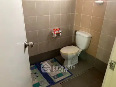 Cozy bathroom with tiled walls and modern fixtures, perfect for a compact space.