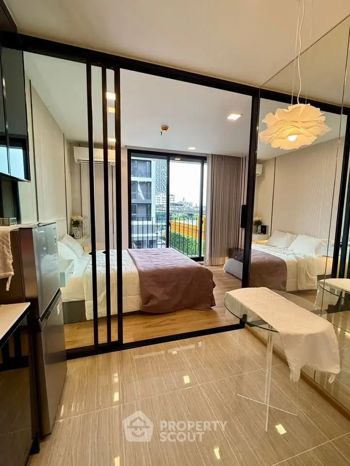 Modern bedroom with glass sliding doors and city view, featuring stylish decor and ample natural light.