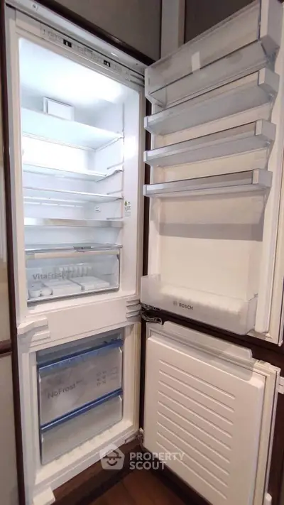 Modern built-in refrigerator with spacious interior and sleek design in a contemporary kitchen.