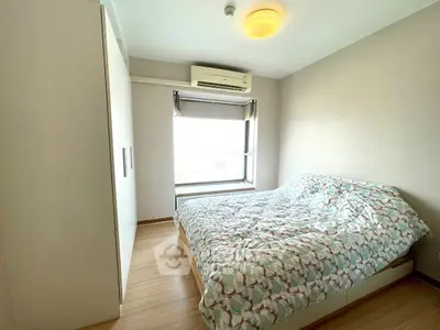 Cozy bedroom with natural light and modern furnishings in a stylish apartment.