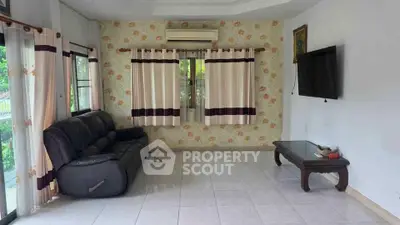 Cozy living room with floral wallpaper, leather sofa, and wall-mounted TV.
