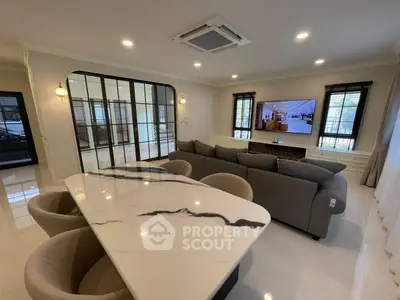 Spacious modern living room with elegant marble dining table and comfortable seating.