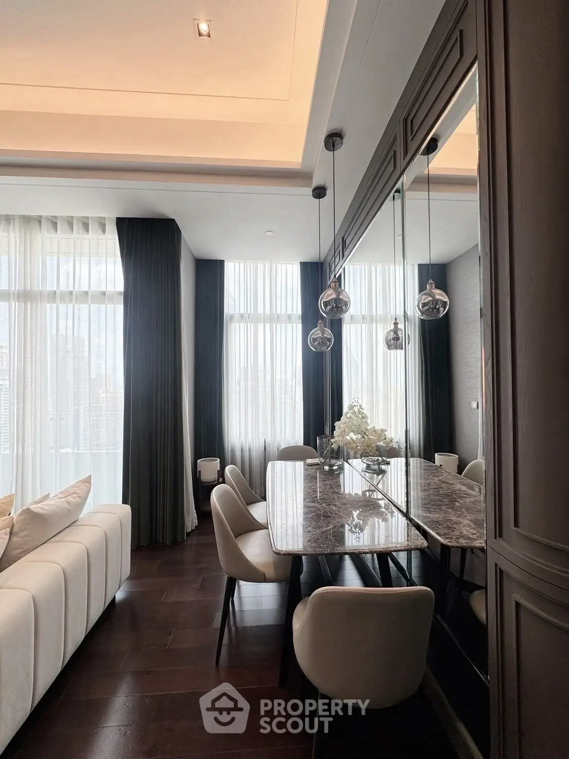 Luxurious dining area with elegant decor and floor-to-ceiling windows in modern apartment.