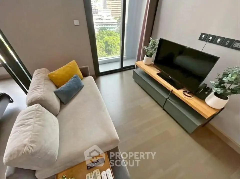 Modern living room with sleek TV setup and cozy sofa, featuring a city view from the window.