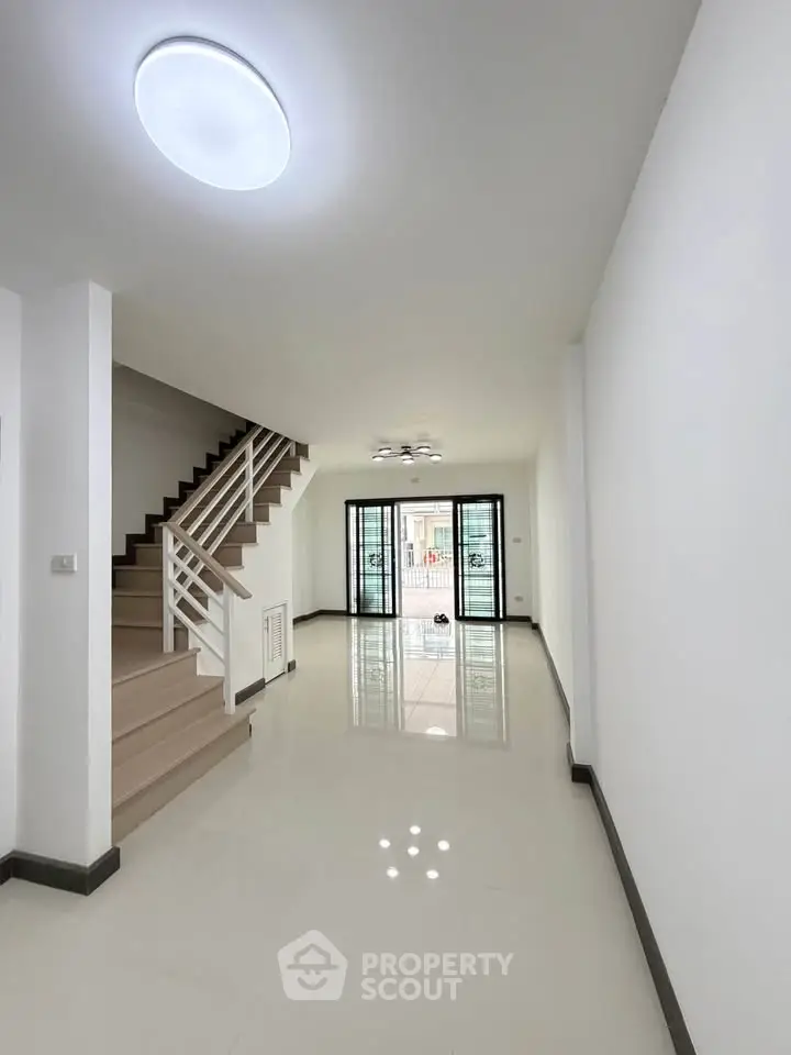 Spacious modern living room with staircase and large windows