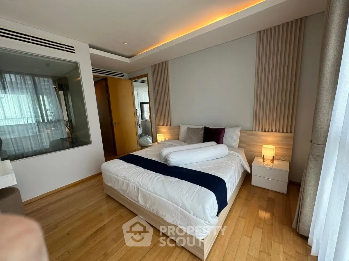 Luxurious bedroom with modern decor and ambient lighting, featuring a comfortable bed and elegant wooden flooring.