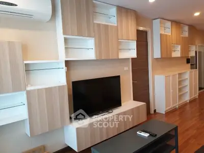 Modern living room with stylish wooden cabinets and sleek TV setup.