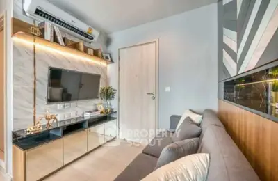 Modern living room with sleek design, featuring a wall-mounted TV and stylish decor.