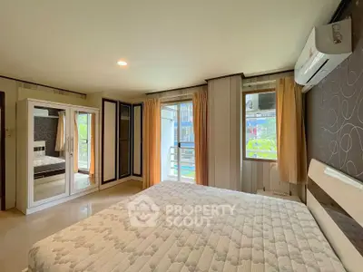 Spacious bedroom with large windows and modern decor in a luxury apartment.