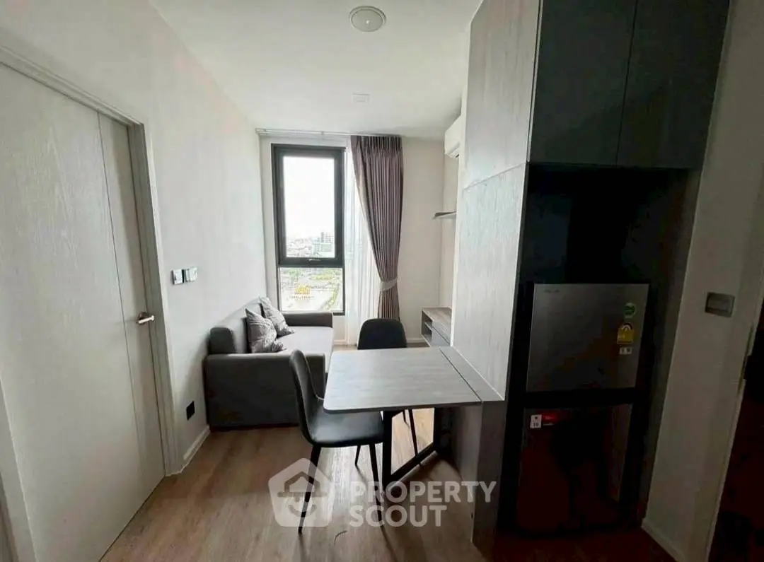 Cozy modern living area with compact dining space and large window view.