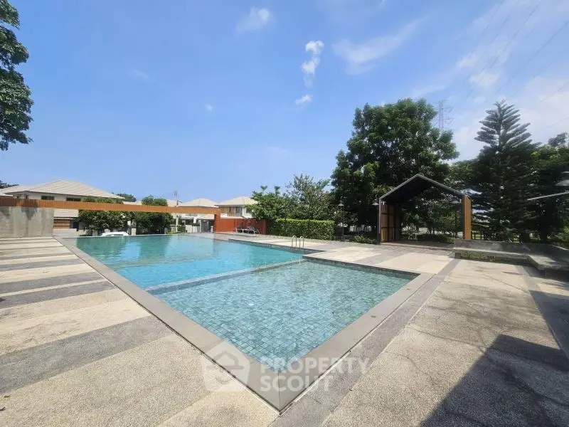 Luxurious outdoor pool area with modern design and lush greenery, perfect for relaxation and leisure.