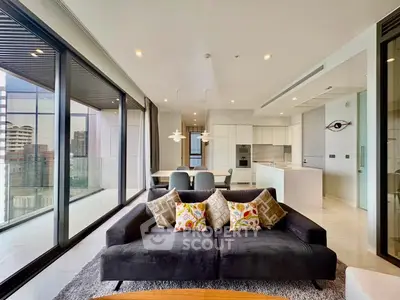 Luxurious modern living room with floor-to-ceiling windows and open kitchen layout in high-rise apartment.