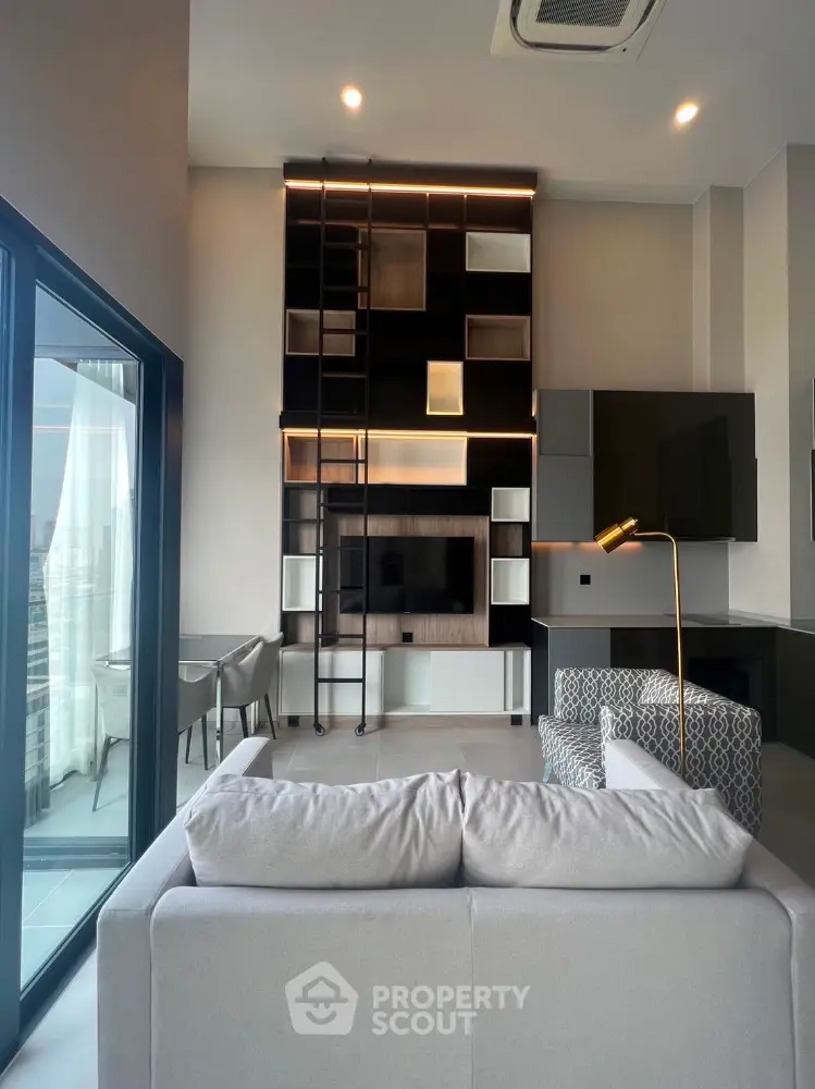 Modern living room with high ceiling, stylish shelving, and balcony view