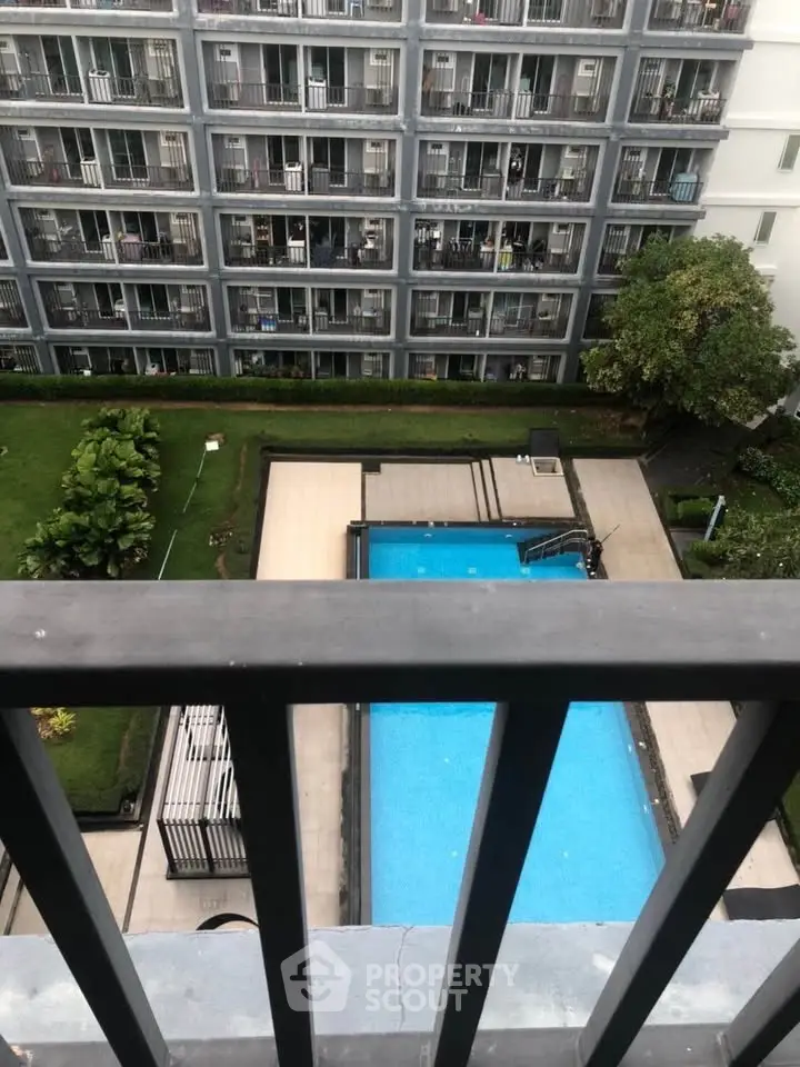 Modern apartment building with pool view from balcony, ideal for urban living.