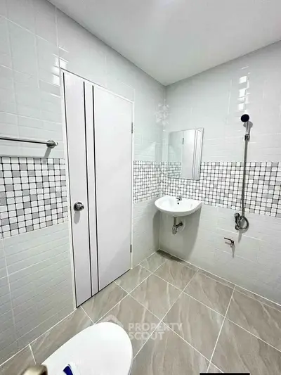 Modern bathroom with sleek tiles and minimalist fixtures, perfect for contemporary living.