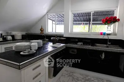 Charming kitchen with black countertops, modern appliances, and elegant decor in a cozy home setting.