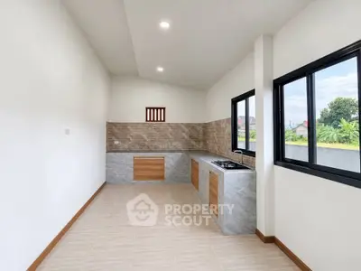 Modern kitchen with sleek design and large windows offering natural light