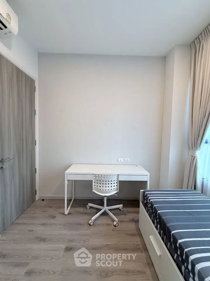 Modern minimalist bedroom with study desk and bed, featuring sleek design and natural light.