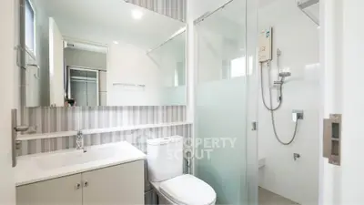Modern bathroom with sleek design, featuring a glass shower and contemporary fixtures.