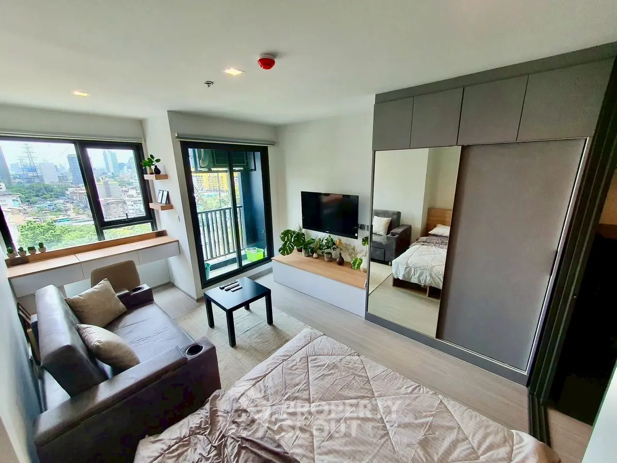 Modern studio apartment with city view, featuring sleek furniture and a cozy atmosphere.