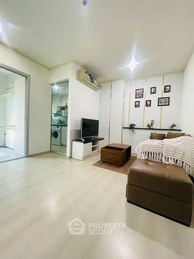 Spacious living room with modern decor and open layout, featuring a cozy seating area and stylish wall accents.