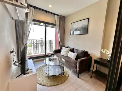 Cozy living room with balcony view, modern decor, and natural light.
