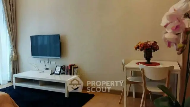 Cozy living room with modern TV setup and elegant dining area, perfect for relaxation and entertainment.