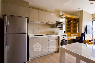 Modern kitchen with sleek cabinetry, stainless steel fridge, and integrated appliances in a stylish apartment.