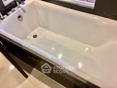 Luxurious bathroom featuring a sleek, modern bathtub with elegant fixtures, perfect for relaxation.